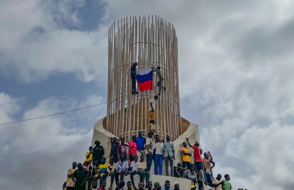 Supporters of Niger’s ruling junta holding a Russian flag at the start of a protest called to fight for the country’s freedom and push back against foreign interference in Niamey, Niger, in August.Credit...Sam Mednick/Associated Press